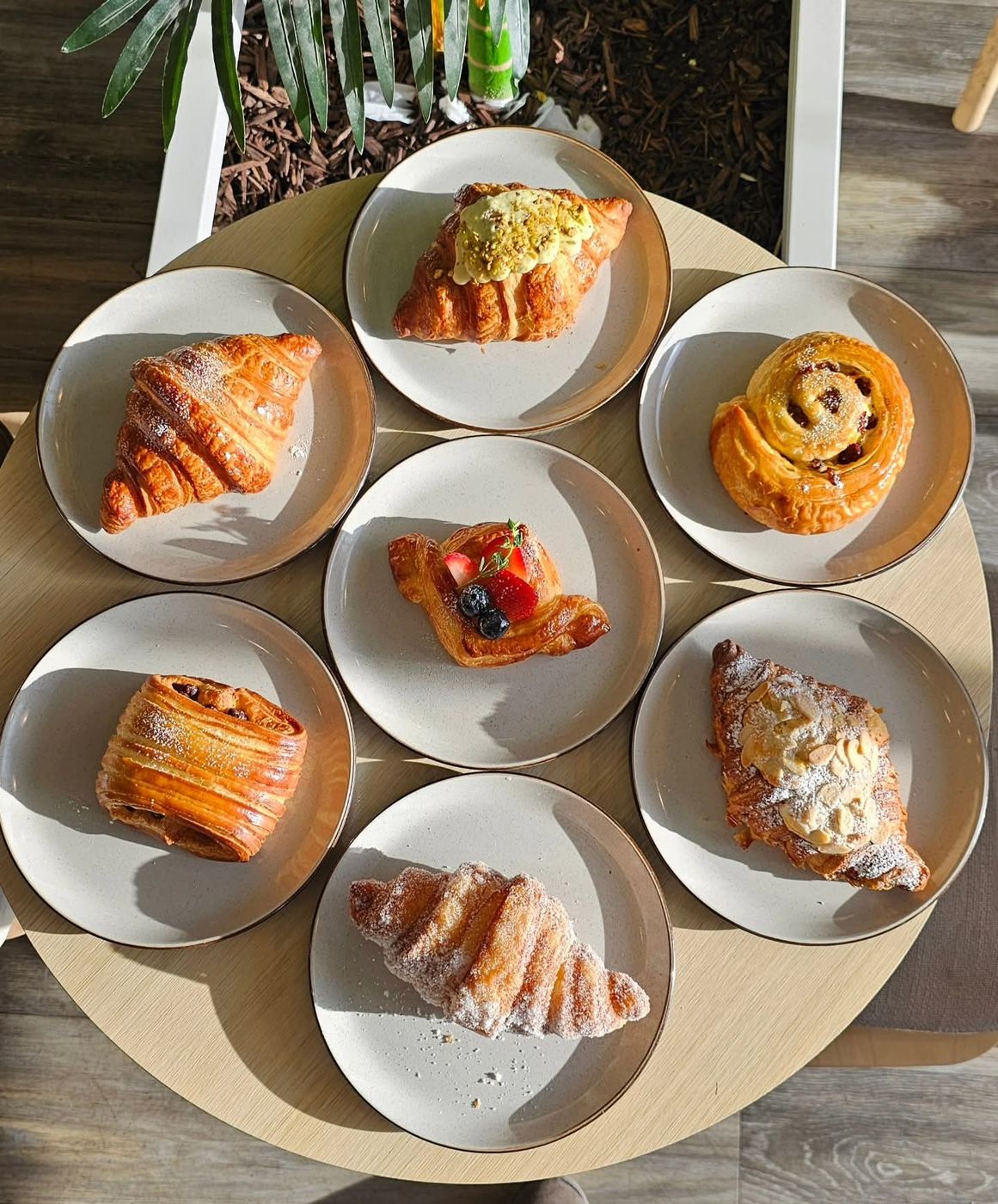 A morning table of croissants and pastries in the sun
